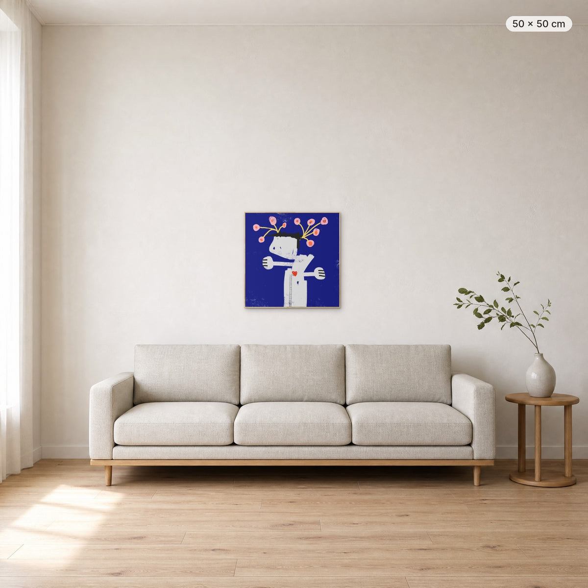 What We Water Grows canvas print in oak floating frame, 50 × 50 cm, shown above a 220 cm sofa