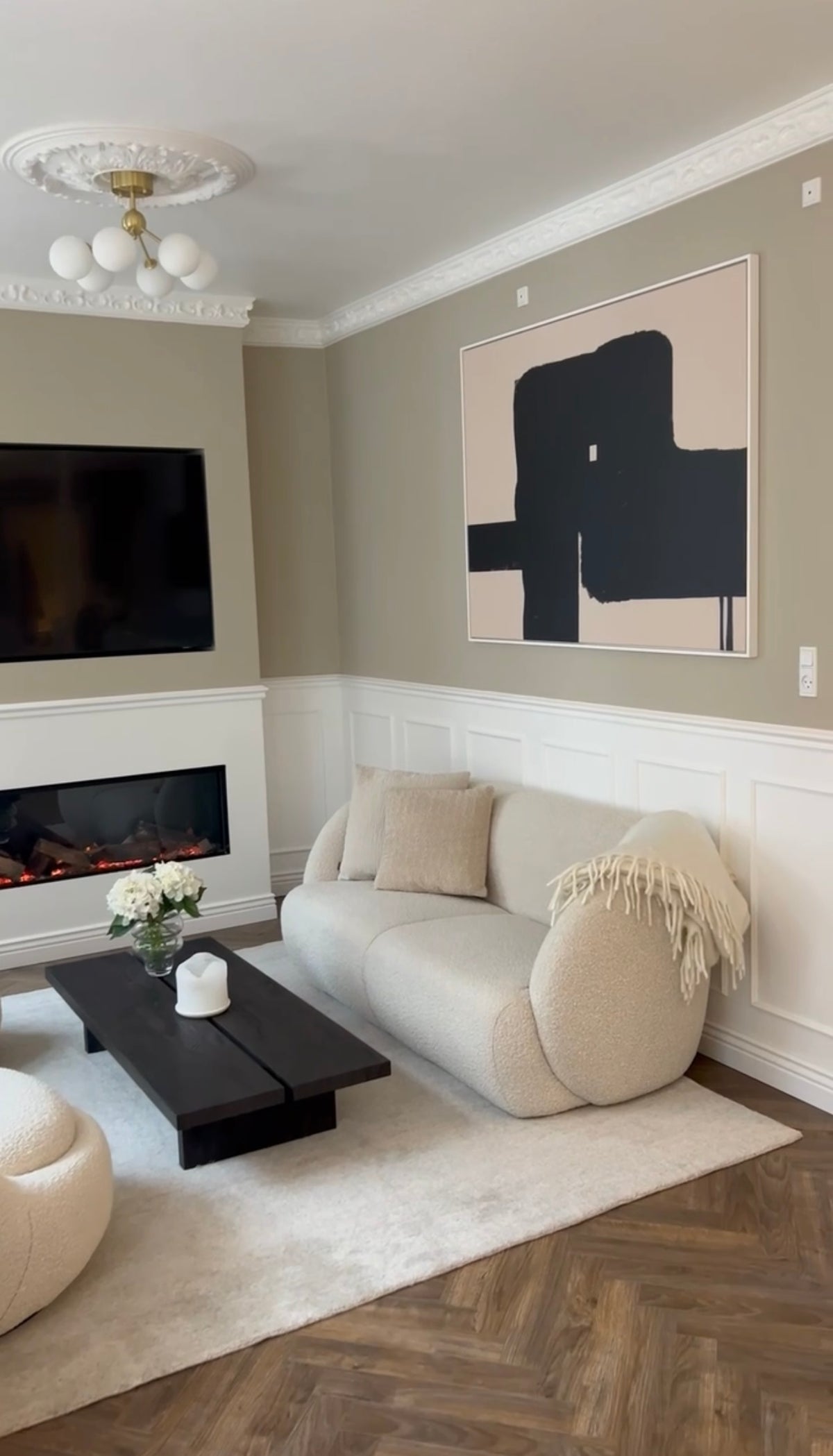 Black abstract canvas by Jacob Lund above a white sofa in a customer's home