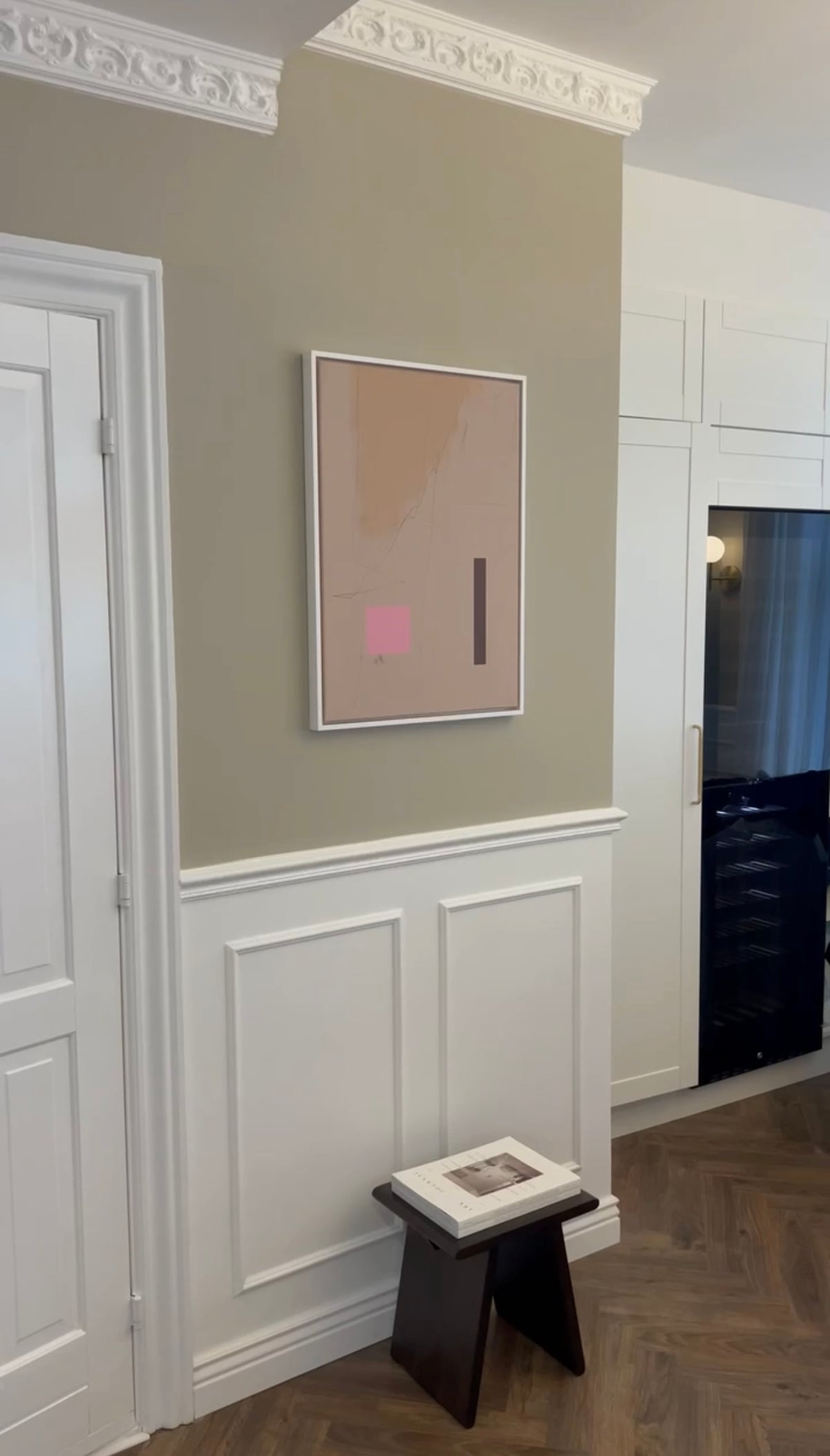 Pink abstract Jacob Lund print beside a doorway in a customer's home