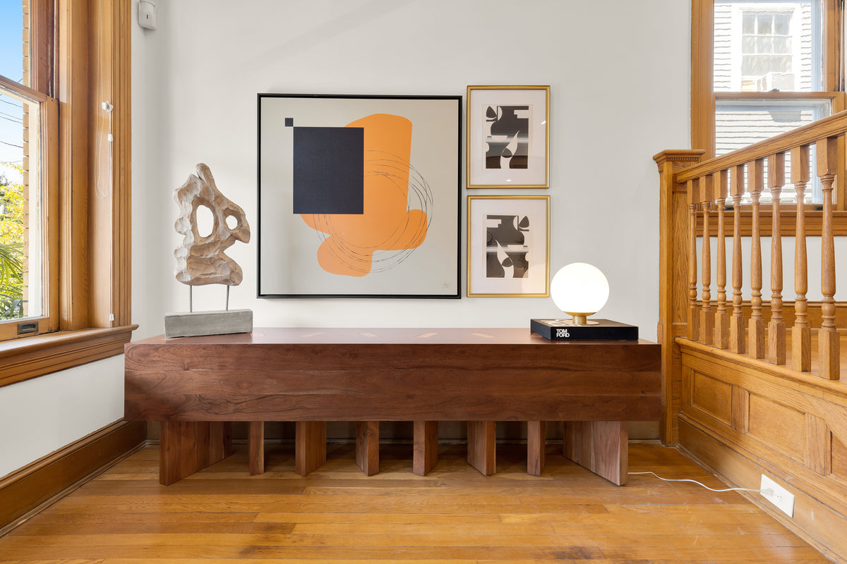 Three framed Jacob Lund pieces above a wooden sideboard in a customer's home